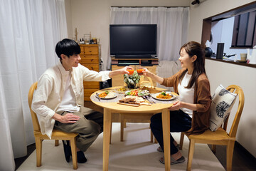 自宅で食事をするカップル