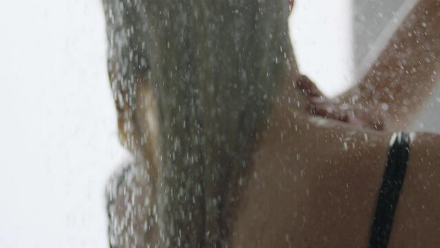 Young girl, woman takes a shower. Shower in a bathing suit of a girl without face recognition.
