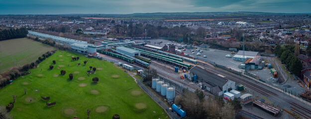 Fototapeta premium Aerial view of Trains on Drogheda macbride train station in ireland, on a line from Dublin to Belfast. Rail platforms and trains passing by on a sunny day.