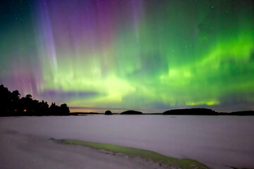 Northern lights dancing over frozen lake in north of Sweden. Farnebofjarden natinalpark.