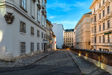Fototapeta na wymiar Narrow cobblestone street among historic buildings in Vienna.