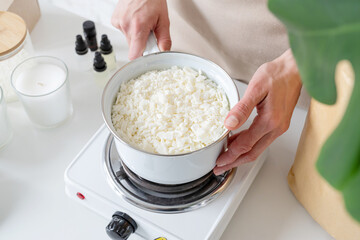 Woman making decorative aroma candles from soy wax