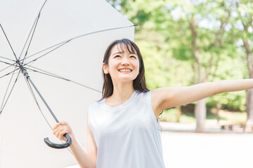 梅雨に傘を差すアジア人女性(雨上がり・晴れ)
