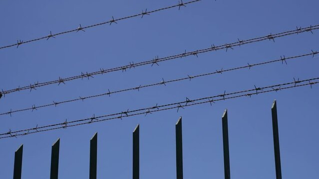 Fence with barbed wire against the sky. Crime, imprisonment, border, prison concept.