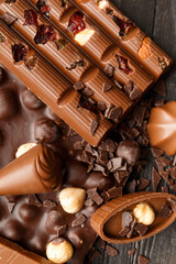 Chocolate with raisins and nuts on a dark wooden background close-up.