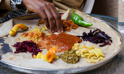 Traditional vegetarian Ethiopian food on a silver  plate - obrazy, fototapety, plakaty