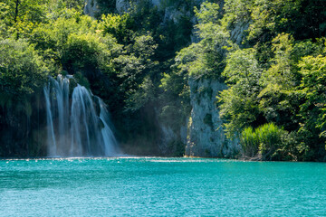 One of the many waterfalls in Plitivice Lakes National Park in Croatia, cascading into the turquoise blue waters of a lake below