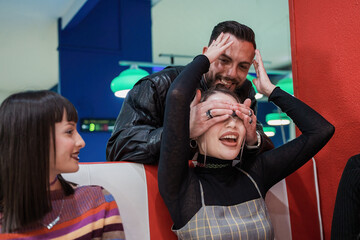 Obraz premium Friends Playing Guessing Game in Arcade Bar