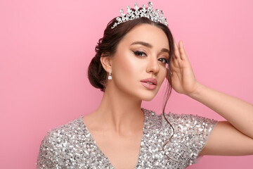 Beautiful young woman wearing luxurious tiara on pink background © New Africa