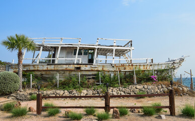 An old boat in unusable condition moored by the sea.