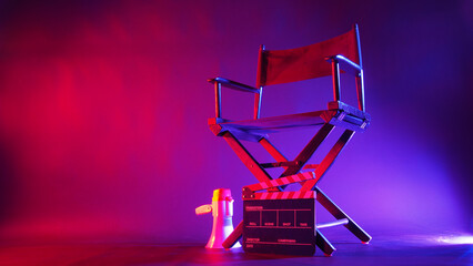 Director chair and clapper board and megaphone in red and blue light color with black background