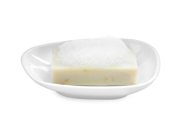 Soap bar with fluffy foam in holder on white background