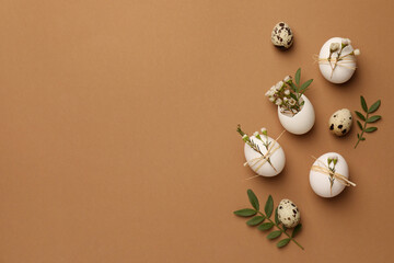Happy Easter. Festive composition with eggs and floral decor on brown background, flat lay. Space for text.