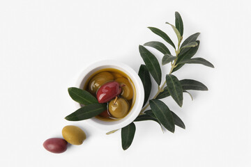 Bowl with different ripe olives and leaves on white background, flat lay