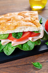 Focaccia Sandwich with Ham, Tomatoes, and Spinach, Sandwich with Italian Flat Bread on Wooden Background