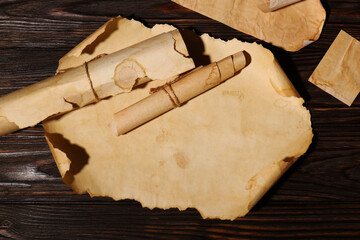 Sheets of old parchment paper on wooden table, flat lay