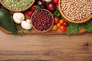 Different vegetables on wooden table, flat lay and space for text. Vegan diet