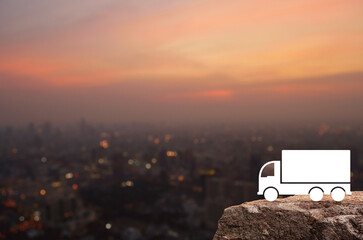 Truck icon on rock mountain over blur of cityscape on warm light sundown, Business transportation service concept