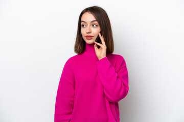 Young Ukrainian woman isolated on white background keeping a conversation with the mobile phone with someone