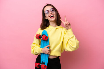 Young Ukrainian woman isolated on pink background with a skate with happy expression