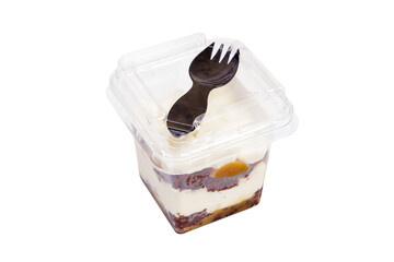 Portion of chocolate caramel mousse in a plastic cup with a fork on the lid on a white background.