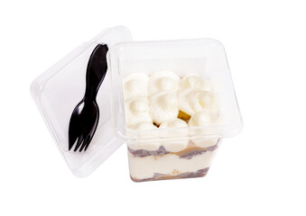 Portion of chocolate caramel mousse in a plastic cup with a fork on the lid on a white background.