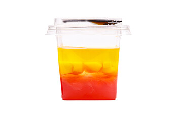 Grapefruit, mango and raspberry jelly in a plastic cup on a white background. Side view.