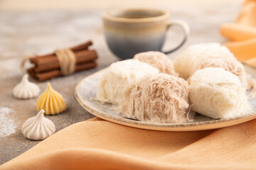 traditional arabic sweets pishmanie and a cup of coffee on brown concrete, side view, selective focus.