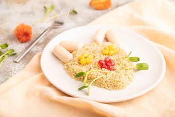 Funny quinoa porridge, and small sausages in form of cat face on brown concrete. side view, selective focus.