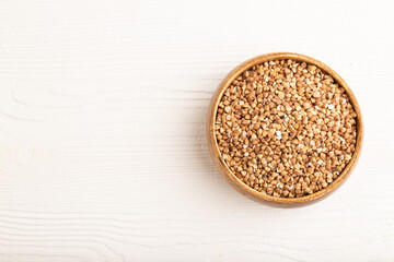 Raw buckwheat on white wooden, top view, copy space