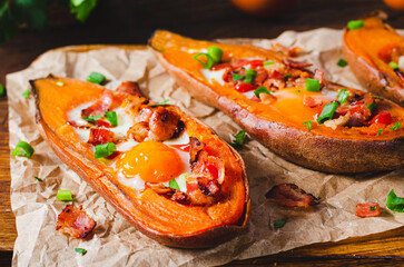 Baked Sweet Potato Stuffed with Egg, Bacon, and Green Onions on Wooden Rustic Background