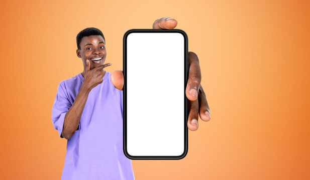 Black man pointing at big phone empty screen, bright background