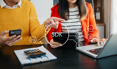 SDK  Software development kit programming language technology concept, Person typing laptop computer and tablet with SDK icon on virtual screen. in office