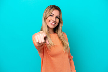 Fototapeta premium Young Uruguayan woman isolated on blue background pointing front with happy expression