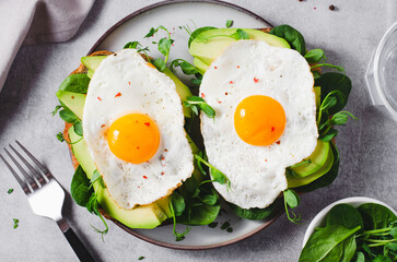 Avocado Sandwich with Fried Egg, Spinach and Green Sprouts, Healthy Breakfast or Snack on Bright Background
