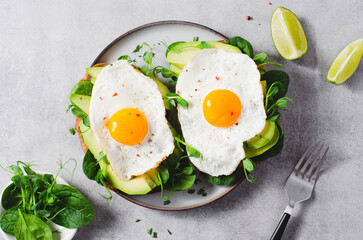Avocado Sandwich with Fried Egg, Spinach and Green Sprouts, Healthy Breakfast or Snack on Bright Background