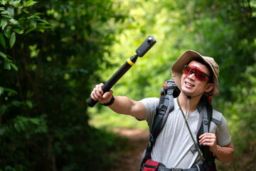 happy asian photographer travel and take photo with 360 digital camera and backpacker trail trekking in nature forest on high mountain, hobby activity in weekend