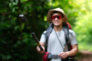 happy asian photographer travel and take photo with 360 digital camera and backpacker trail trekking in nature forest on high mountain, hobby activity in weekend