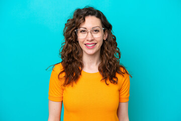 Young caucasian woman isolated on blue background With glasses with happy expression