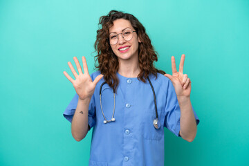 Young nurse caucasian woman isolated on blue background counting eight with fingers