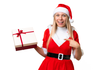Young blonde woman with christmas hat and holding a gift over isolated chroma key background with surprise facial expression
