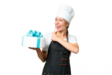 Young pastry blonde woman with a big cake over isolated chroma key background celebrating a victory