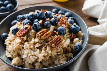 Oatmeal Bowl, Oat Porridge with Blueberry and Pecans in a Bowl on Rustic Background, Healthy Snack or Breakfast