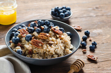 Oatmeal Bowl, Oat Porridge with Blueberry and Pecans in a Bowl on Rustic Background, Healthy Snack or Breakfast