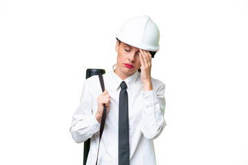 Young architect woman with helmet and holding blueprints over isolated background with headache