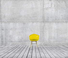 Yellow modern chair on an old wooden floor or deck isolated against a concrete wall background....