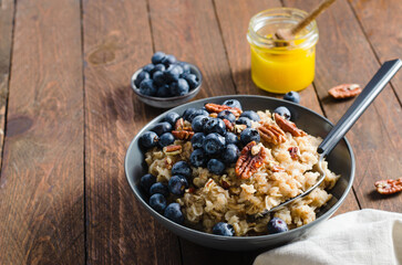 Oatmeal Bowl, Oat Porridge with Blueberry and Pecans in a Bowl on Rustic Background, Healthy Snack or Breakfast