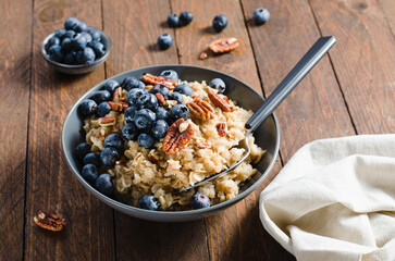 Oatmeal Bowl, Oat Porridge with Blueberry and Pecans in a Bowl on Rustic Background, Healthy Snack or Breakfast