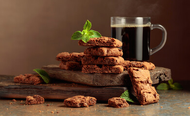 Pieces of fresh brownie with mint and a cup of black coffee.