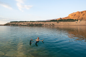 A male tourist relaxes in the water of the Dead Sea
